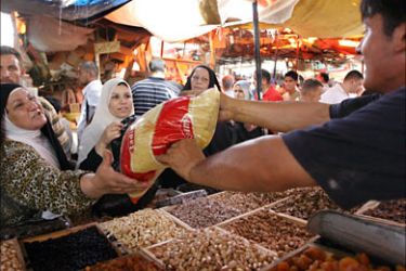 f_A woman buys a bag of imported rice at a stall in the Shorja market, the main stockpile central in Baghdad on August 30, 2008, as Iraqi households prepare for the Muslim holy month