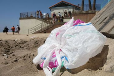 The wind blows a plastic bag around the beach near the Manhattan Beach Pier