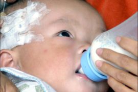 afp : A Chinese baby suckles on a bottle of milk as he undergoes treatment at a hospital in Xian on September 17, 2008. Anxious parents rushed their babies in for medical