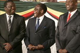 r_Zimbabwe's President Robert Mugabe (C) laughs with opposition leader Morgan Tsvangirai (L) and Arthur Mutambara, leader of breakaway faction of the