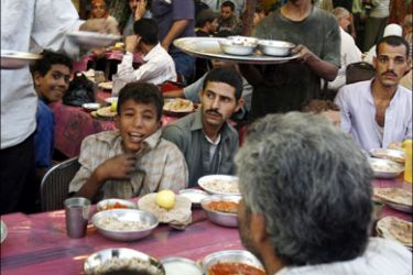 r : Egyptians eat Iftar, the evening meal breaking the daily fast, at a charity providing free food during Ramadan in Cairo September 20, 2008. Muslims around the world abstain from