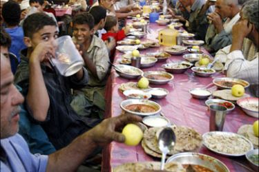 r : Egyptians eat Iftar, the evening meal breaking the daily fast, at a charity providing free food during Ramadan in Cairo September 20, 2008. Muslims around the world abstain from