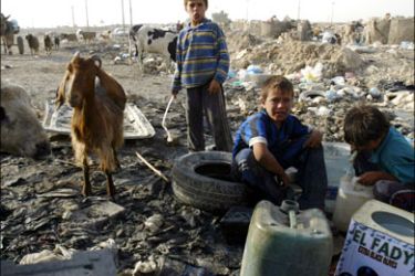 afp : Iraqi children fill water containers from a hose pipe laid out at a garbage dump in the former Army Rashid base now also a housing slum in southern Baghdad on September 25,