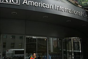 r_A security guard puts on a reflective vest while standing outside an American International Group (AIG) building in New York's financial district September 16, 2008
