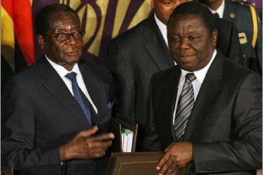 AFPFromL) Zimbabwe President Robert Mugabe and new Prime Minister Morgan Tsvangirai pose after signing the power-sharing accord