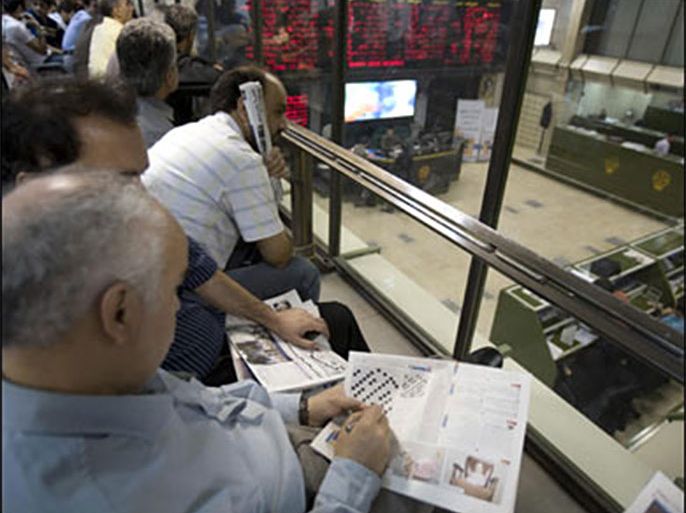 r/A stock market trader works on a crossword puzzle at Tehran's Stock Exchange September 30, 2008.