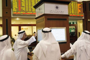 Traders monitor stocks from the trading floor at the Dubai Stock Exchange in the Dubai World Trade Center October 12, 2008. Dubai Financial Market cut the limit down it imposes