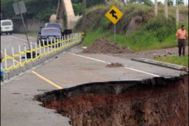 f/A person walks on the border of a damaged national road in the outskirts of Tegucigalpa, on October 22, 2008.