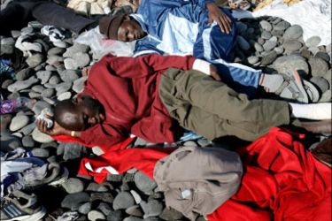 afp : Some of the 69 illegal immigrants lie exhausted after arriving at San Blas on the Spanish Canary island of Tenerife on October 15, 2008. Nearly 5,400 illegal immigrants have