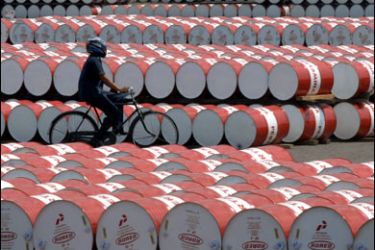 f/(FILES) -- A file photo taken on May 6, 2008 shows a worker of state oil company Pertamina cycling past barrels filled with fuel in Jakarta. OPEC President Chakib Khelil said here on October 23, 2008 that the oil producers' cartel will decide to cut production at a meeting on Friday,
