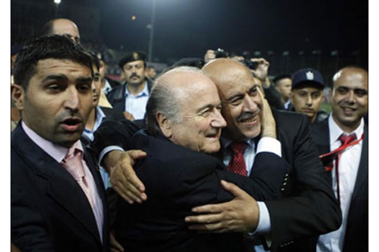 afp : FIFA head Joseph Blatter (C-L) and the head of Palestinian football federation Jibril Rajub (C-R), hug before the start of a friendly football match between the Palestinian
