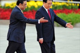 Visiting Pakistan President Asif Ali Zardari (L) and Chinese President Hu Jintao (R) both gesture while walking along the red carpet during a review of the honour guard welcoming ceremony at the Great Hall of the People in Beijing on October 15, 2008
