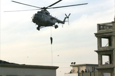 An Indian National Security Guard (NSG) commando abseils from a helicopter onto the rooftop of Nariman House at Colaba Market in Mumbai on November 28, 2008