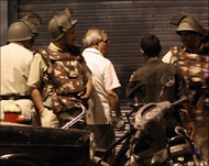 قوات هندية ترافق أحد الرهائن بعد تحريره من مجمع سكني في مومباي (الفرنسية)