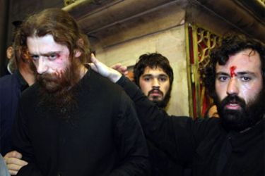Greek orthodox monks with bruises and blood on their faces are seen at the Church of the Holy Sepulcher in Jerusalem's old city on November 9, 2008, after violence broke out between Greek Orthodox and Armenian clergy men during the Armenian feast of the Holy Cross. Greek and Armenian Orthodox faithful kicked, punched and hit each other with candles today in the Holy Sepulchre, the church built on the site where Christians believe Jesus was buried and resurrected.