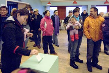 epa01560197 Cecilie Markussen casts her vote in the ballot box in Nuuk, Greenland, on 25 November 2008.