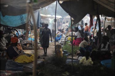 f/Residents from the North Kivu town of Kiwanja sit under makeshift shelters they set up in front of a UN peacekeepers camp on the outskirts of the town on November 07, 2008.