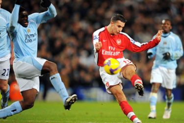 Arsenal's Dutch forward Robin Van Persie (C) shoots past Manchester City's English defender Micah Richards (L) during the English Premier league football match at The City