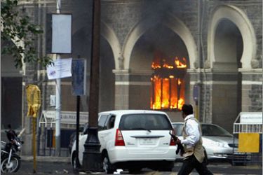 REUTERS/A member of the anti-terrorist squad runs in front of the burning Taj Mahal hotel during a gun battle in Mumbai November 29, 2008. Operations to dislodge militants at the Taj Mahal hotel in