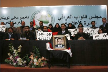 f/Members of the Iraqi parliament loyal to anti-US Shiite cleric Moqtada al-Sadr, hold banners that read, "No, no agreement" behind a portrait of killed Sadrist member Salih al-Okaili in Baghdad on November 27, 2008,