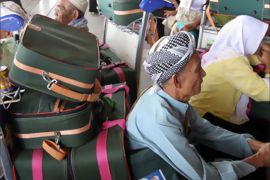 Cambodian Muslim passengers, awaiting flights to Bangkok, sit next to luggage at the departure terminal of Phnom Penh International airport on November 26, 2008