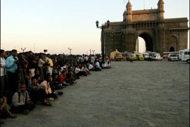 f/Indian and International media representatives stand together at the landmark Gateway of India monument opposite the Taj Mahal hotel in Mumbai on November 27, 2008.