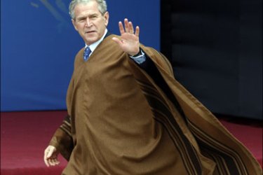 r : U.S. President George W. Bush wears a typical Peruvian poncho while walking to the group photo at the Asia-Pacific Economic Cooperation (APEC) summit in Lima, November
