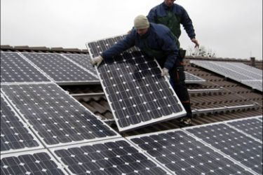 r : Workers install solar panels on the roof of a kindergarten in the town of Falkensee near Berlin December 10, 2008. While the rest of the economy plunges into recession,