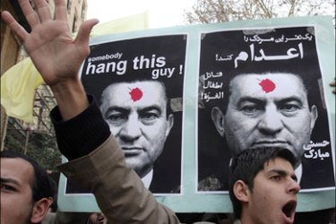 r : Demonstrators carry pictures of Egypt's President Hosni Mubarak as they shout slogans in front of The Interests Section of the Arab Republic of Egypt in Tehran December 8,