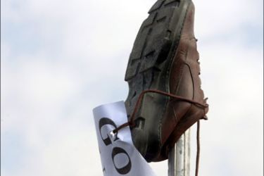 afp : A shoe and a sign reading, 'Go out USA', is placed on a pole as Iraqis protest against yesterday's visit by US President George W. Bush and the arrest of an Iraqi