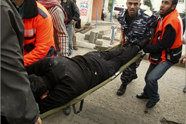 REUTERS/ Palestinian rescue personnel carry the body of a Palestinian after Israeli air force attacked Gaza City December 27, 2008. Israel's air force fired about 30 missiles at targets in the