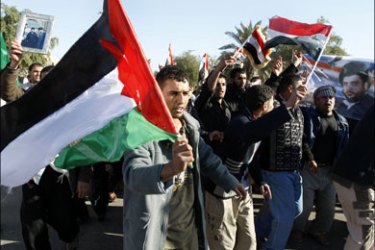 afp :  Iraqi demonstrators wave the Palestinian (L) and Iraqi flags during a protest organised by the Shiite Sadr movement in Mustansiriya square in Baghdad on December 29, 2008