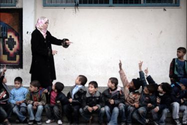 afp : A Palestinian teacher points to her pupils raising their hands to answer a question at a primary school run by UNRWA (UN Relief and Works Agency) in Beit Lahia in the