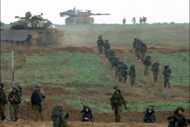 r : Israeli tanks provide security to soldiers returning to Israel early morning January 18, 2009 after a combat mission in Gaza. Palestinian militants in the Gaza Strip launched