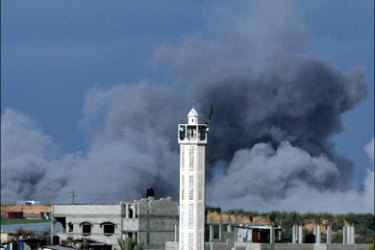 afp : Smoke billows behind the minaret of a mosque following an Israeli air strike on the northern Gaza Strip as seen from the Jabalia refugee camp on January 2, 2009. Israeli