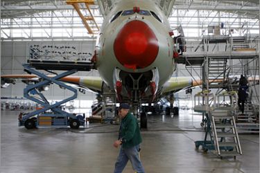 epa01615287 A worker walks in front of an Airbus A380 in the A380 factory in Blagnac near Toulouse, France, 27 January 2009. France is stepping in to support its aerospace industry