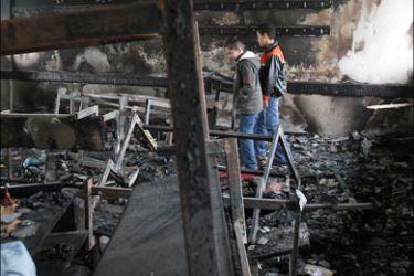 afp : Palestinian schoolboys inspect a burnt classroom at a school run by UNRWA in Beit Lahia in the northern Gaza Strip on January 24, 2009. Some 200,000 Gaza children