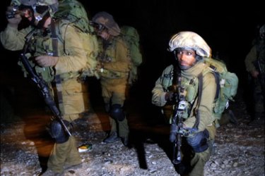r : Israeli soldiers advance near the border with northern Gaza during a ground operation by the Israeli army late January 3, 2009. Israeli troops clashed with Hamas fighters