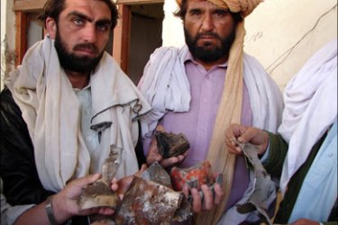 afp : Pakistani tribesmen hold pieces of missile in the house which was destroyed in a US missile strike near Mir Ali in North Waziristan district on January 24, 2009. Six more