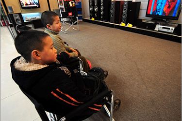 AFP - This photo taken on January 19 2009 shows boys watching movies in a television showroom as their parents shop at an electronics and home appliances store in Zhengzhou in central China's Henan Province. The central government in