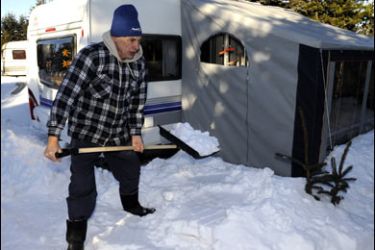 f/Winter camper Dietmar Lindberg removes snow in front of his caravan on January 12, 2009 at a camping site in Altenberg, eastern Germany.