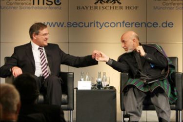 afp : German Defence Minister Franz Josef Jung (L) and Afghan President Hamid Karzai shake hands as they sit on the podium on the last day of the 45th Munich Security