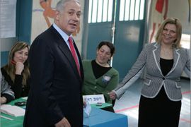 AFPIsrael's Likud party leader and former Prime Minister Benjamin Netanyahu casts his ballot as his wife Sara stands next to him at a polling station in