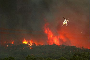 AFP - A fire-fighting helicopter approaches an out of control fire in the Bunyip State Park near Labertouche, some 125 kilometres west of Melbourne, on February 7, 2009. More