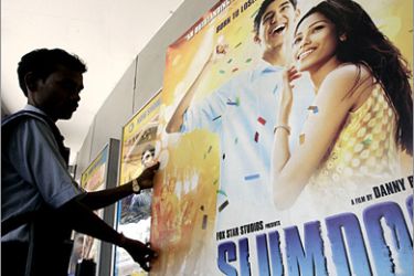 AFP - An Indian cinema workers positions a poster for the movie "Slumdog Millionaire" in Kolkata on February 23, 2009. India basked in the reflected glory of "Slumdog Millionaire" after the movie's Oscar success, although there was little