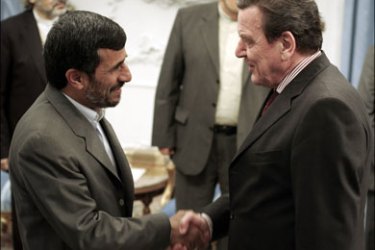 r : Former German Chancellor Gerhard Schroeder (R) shakes hands with Iran's President Mahmoud Ahmadinejad before an official meeting in Tehran February 21, 2009.
