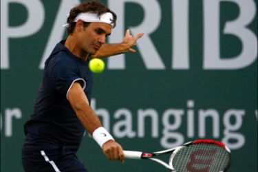 afp : INDIAN WELLS, CA - MARCH 14: Roger Federer of Switzerland returns a backhand to Marc Gicquel during the BNP Paribas Open at the Indian Wells Tennis Garden on