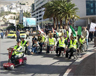 معاقون فلسطينيون بنابلس خلال مسيرة للمطالبة بحقوقهم (الجزيرة نت) 