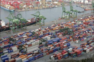 r : Cargo containers are stacked at a yard in Busan port, the country's biggest and the world's No. 5 container port, in Busan, about 420 km (262 miles) southeast of Seoul, March