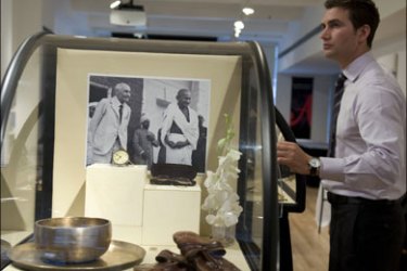 afp : An employee of Antiquorum Auctioneers stands near Mahatma Gandhi's round glasses, his watch, his plate and bowl and his sandals at the auction house Sunday.March 1,